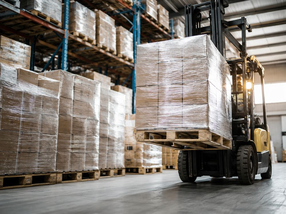 Pallets of packaged goods staged for distribution in a warehouse aisle